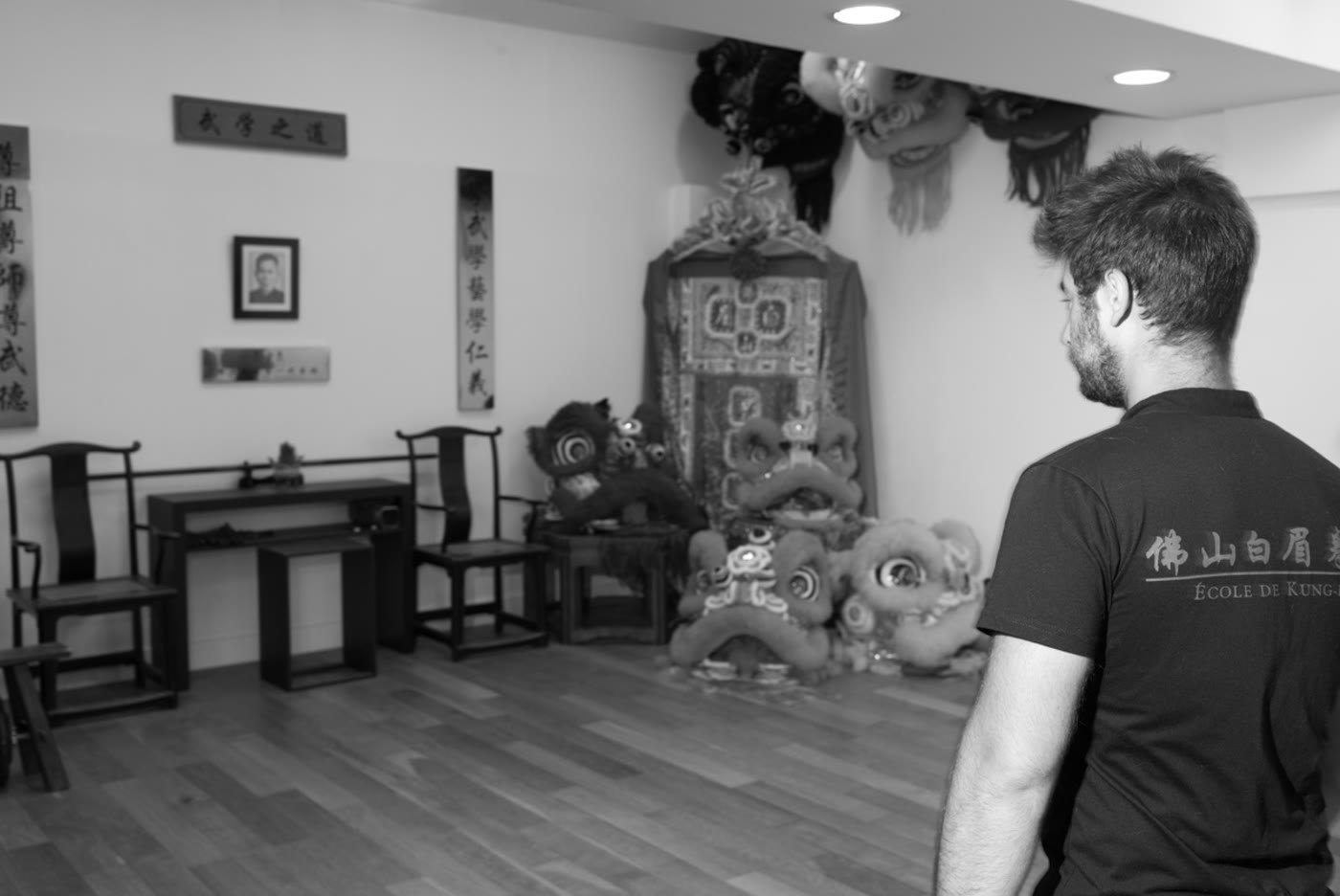 Un pratiquant dans l’école devant les lions traditionnels